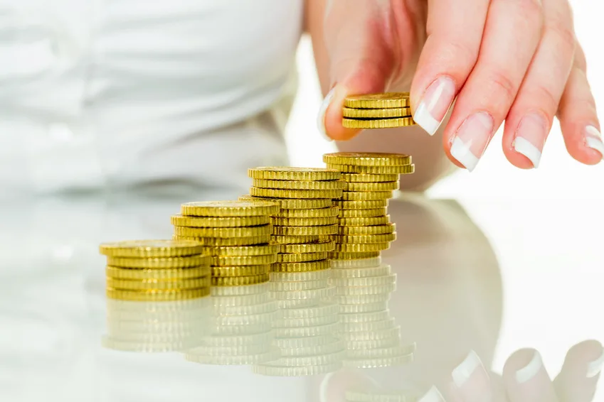 Frau mit Münzstapel beim Geld sparen
